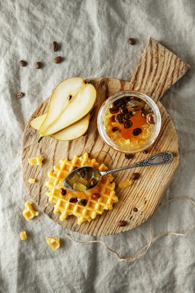candied fruit jelly. pear marmalade with coffee beans. Jar of pear jam on wooden cutting board on linen background