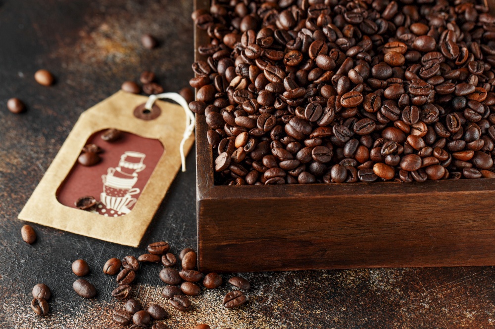 Black coffee beans studio shot. Freshly roasted coffee beans in a wooden box