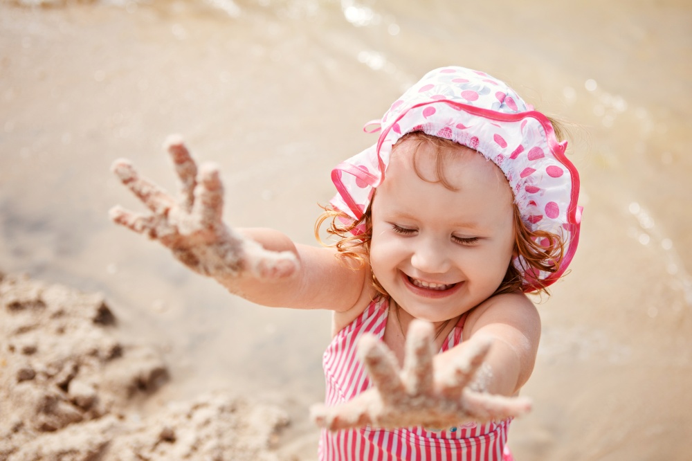 Cute little girl playing on the beach