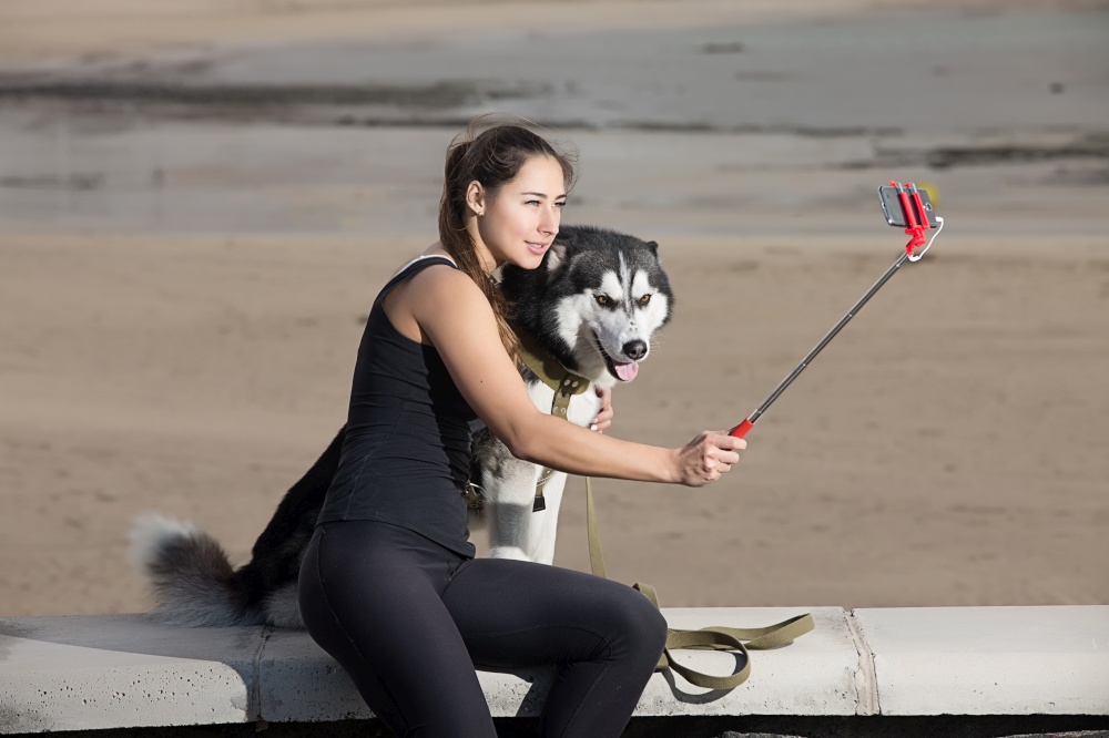 Young woman posing for a selfie with her dog outside. . Woman doing selfie with a dog