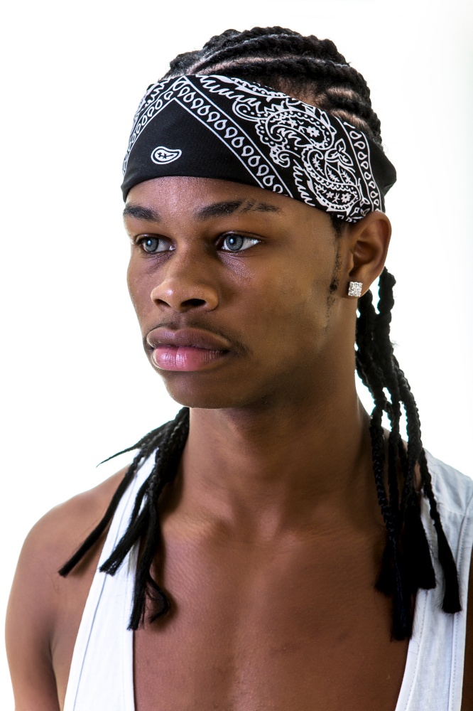 Young African-American man in black urban do-rag looking away isolated on white.. Young black man in do-rag looking away