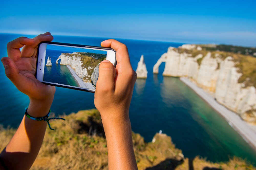 Smartphone in hand photographing, Chalk cliffs Cote d&rsquo;Albatre. Etretat Normandie France, Europe. Smartphone in hand photographing, Chalk cliffs Cote d&rsquo;Albatre. Etretat