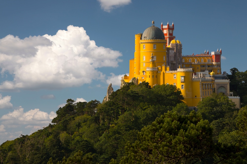 Portugal. Sintra. The Pena Palace on a cliff surrounded by forest and clouds. Portugal. Pena Palace in Sintra
