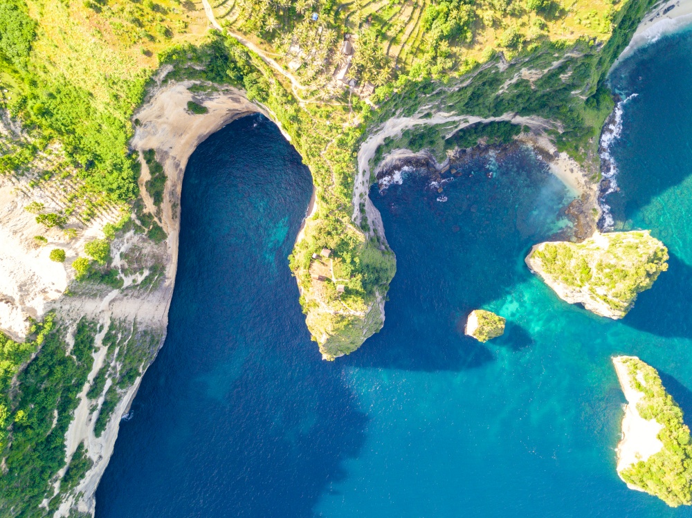 Indonesia. Sunny weather and the rocky coast of the tropical island. The azure water of the ocean. Aerial view. Winding Rocky Tropical Coast. Aerial View