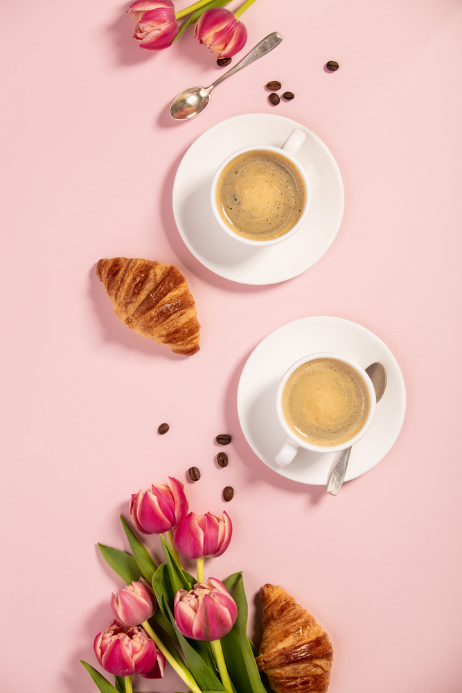 Morning coffee, croissants and a beautiful flowers. Cozy breakfast. Flat lay composition for bloggers, magazines, web designers, social media and artists.
