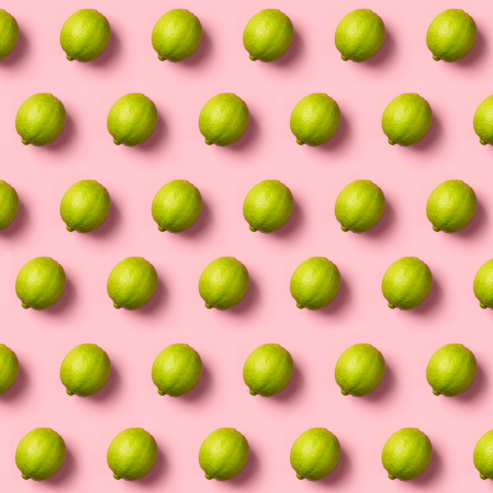 Limes pattern on pink background. Creative food concept. Flat lay composition for bloggers, magazines, web designers, social media and artists.. Limes pattern on pink background. Creative food concept. Flat la
