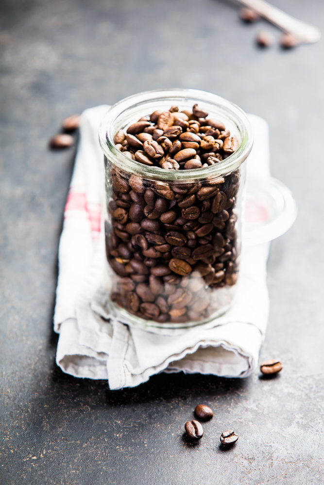 Coffee composition on dark background. Coffee composition on dark background. Coffee beans in glass jar