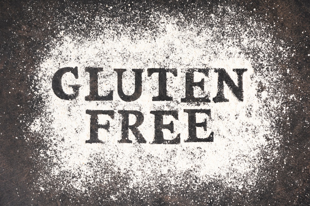 Gluten free written in flour on vintage baking sheet, flat lay