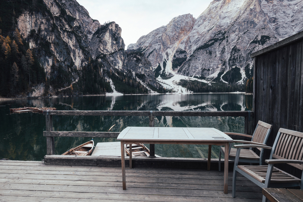 Wooden table and chair at the alpine mountain lake. Lago di Braies, Dolomites Alps, Italy. Wooden table and chair at the alpine mountain lake