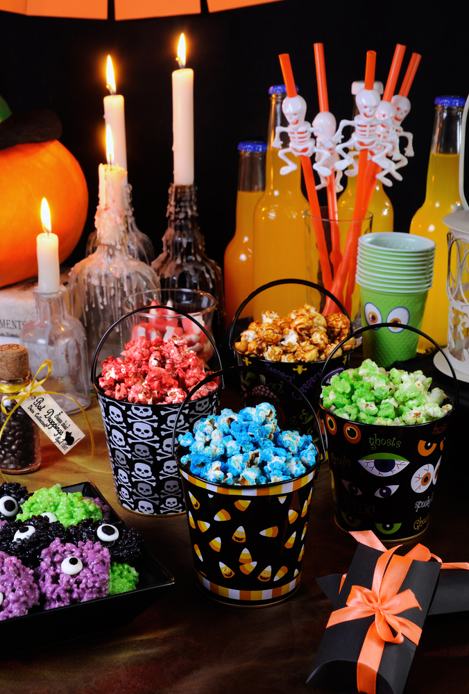 Sweet colored popcorn on the table among Halloween sweetness.