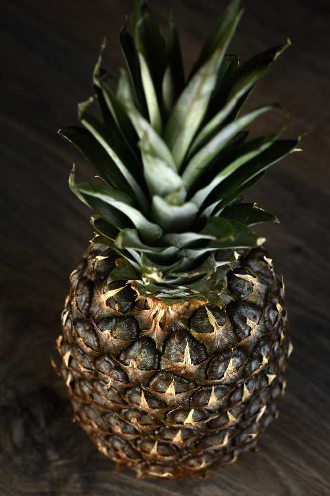 Pine Apple Whole Tropical Fruits with Leaves wooden background Useful Natural Organic Food Style. Close-up.