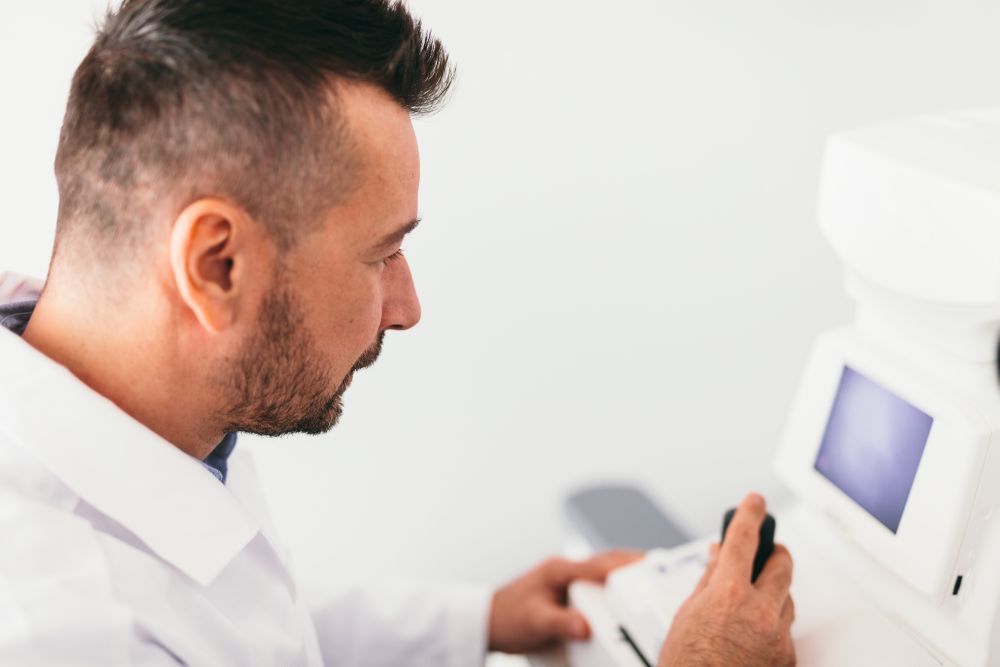 Optician examining his patient&rsquo;s eye on a machine. Professional medical equipment.. Optician examining patient&rsquo;s eye on a machine.