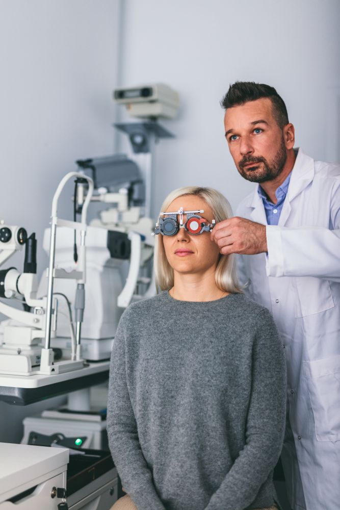 Optician checking patient&rsquo;s eyesight with trial frame. Doctor&rsquo;s appointment and medical test.. Optician checking patient&rsquo;s eyesight with trial frame.