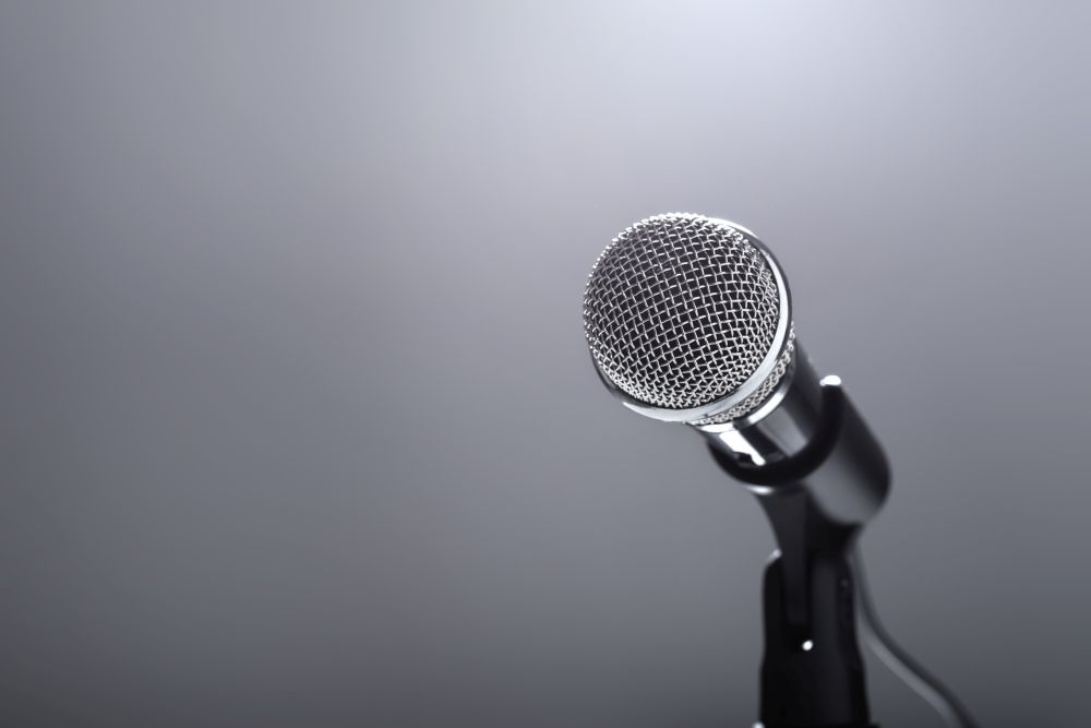 Microphone on grey background. Singing and music. Auditioning and performing.. Microphone on grey background.
