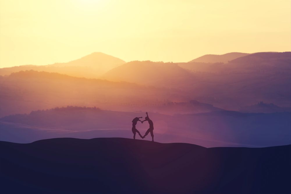 Young couple creating a heart out of their bodies on a hill during a sunset. Love. Valentine&rsquo;s day. 3D illustration.. Young couple creating a heart out of their bodies