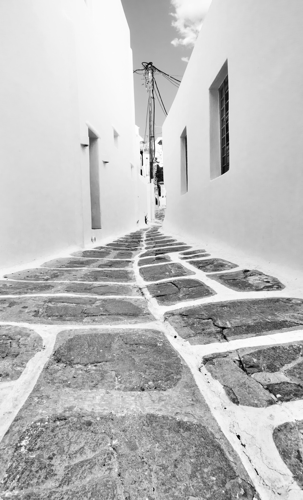 Perspective of a narrow street in Mykonos, Greece. Black and white image