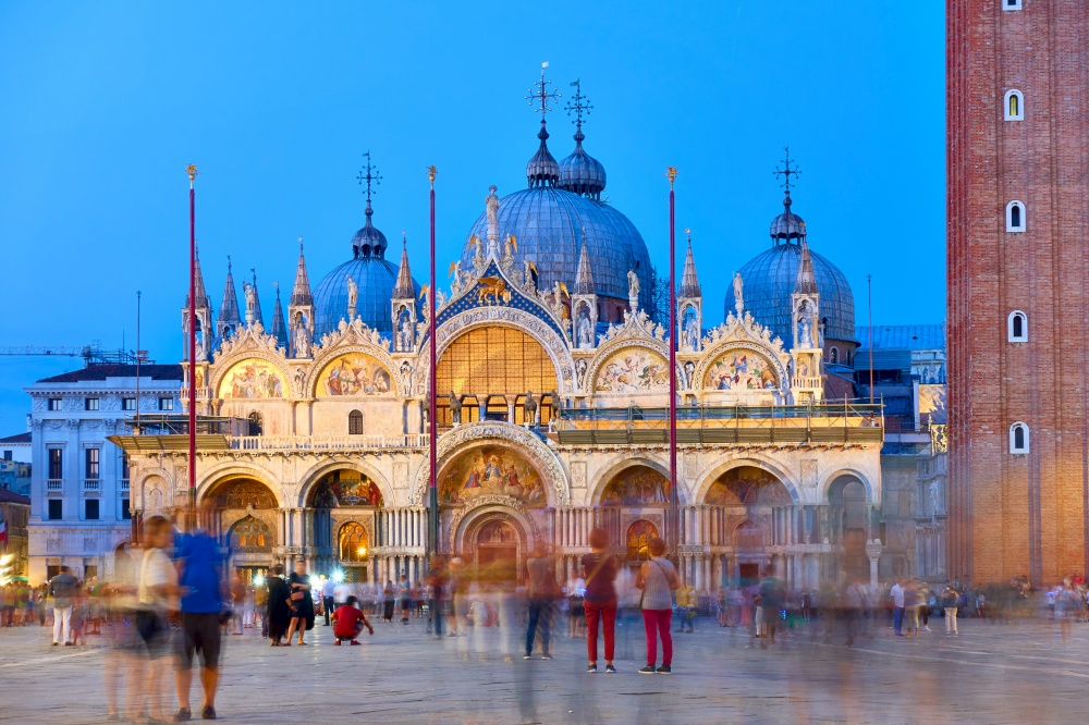 Cathedral Basilica of Saint Mark in Venice at dusk and people in motion blur in the square, Italy. Cityscape, landmark