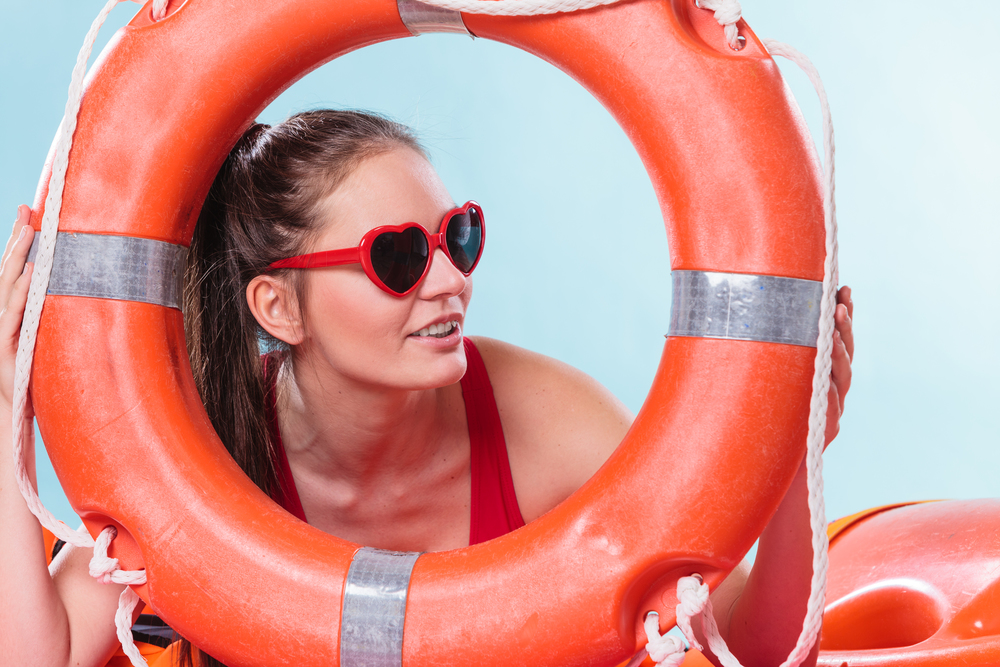 Young woman girl in heart shape sunglasses with ring buoy lifebuoy. Summer safety security.. Woman in sunglasses with ring buoy lifebuoy.
