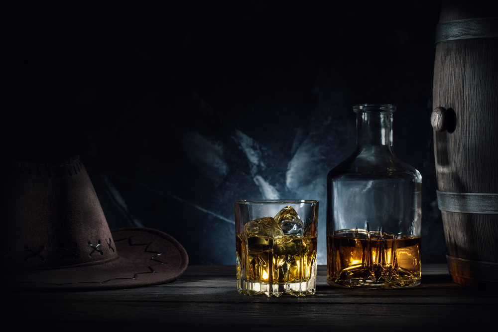 Whiskey and hat and barrel on dark marble background. Whiskey and hat and barrel on dark background