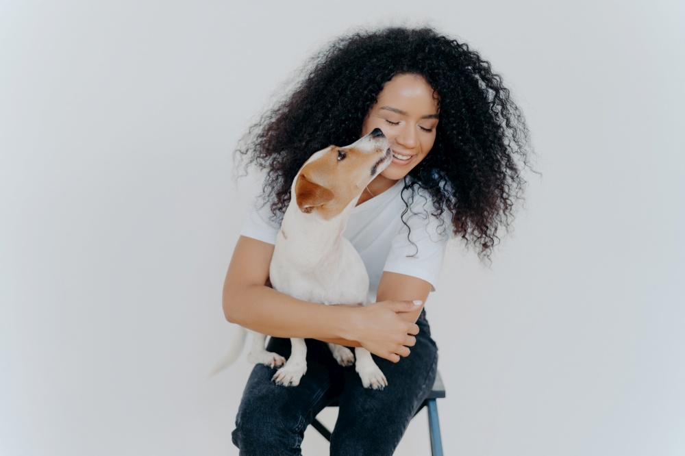 Happy woman cuddling with her Jack Russell Terrier, both enjoying a playful moment
