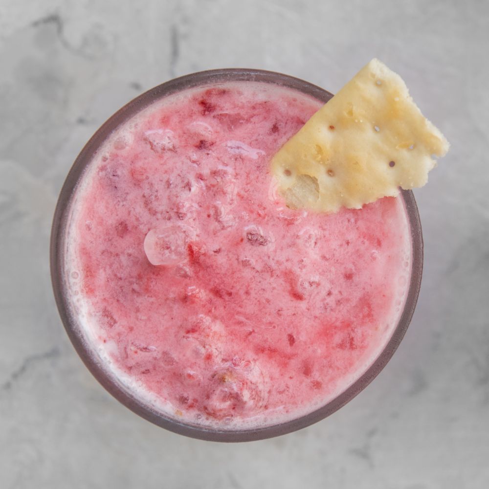 Strawberry smoothie with cookie. Strawberry smoothie with cookie on a white concrete background. Square cropping