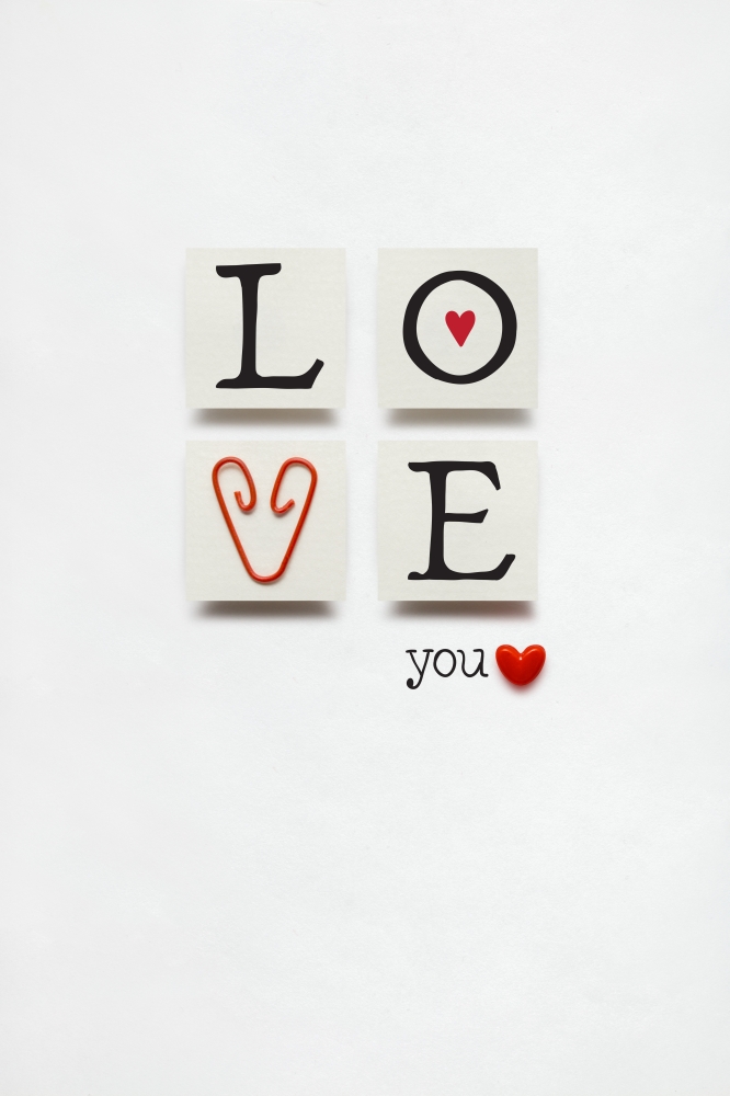 Creative valentines concept photo of love sign with a clip on white background.