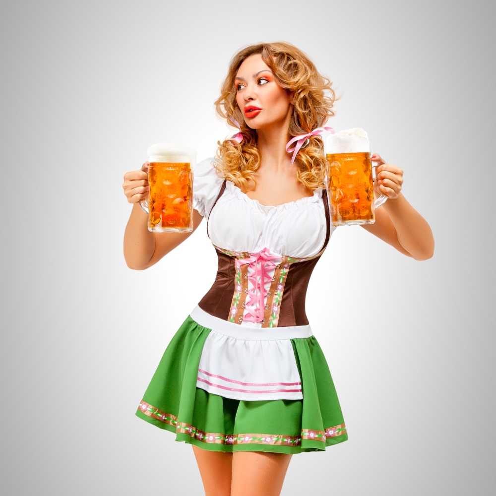 Serving with smile.. Beautiful Oktoberfest woman wearing a traditional Bavarian dress dirndl serving beer mugs on grey background.