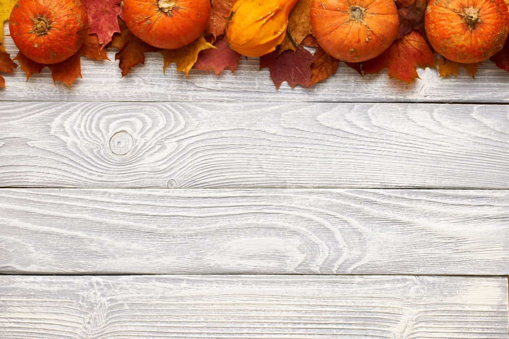Autumn leaves and pumpkins over old wooden background . Autumn leaves and pumpkins over old wooden background with copy space
