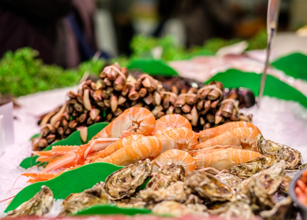 Fresh langoustines, razor clams and oysters at seafood market