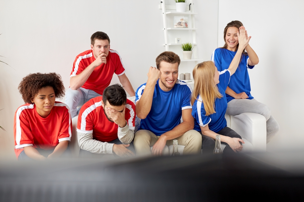 people, leisure, rivalry and sport concept - happy and sad friends or football fans watching soccer game or match at home