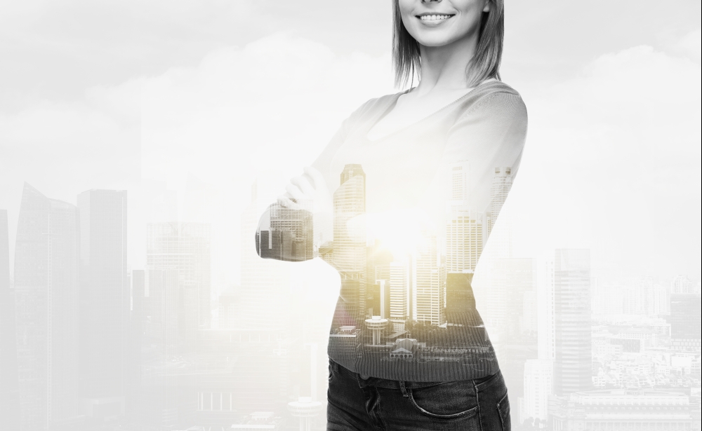 people concept - smiling young woman in casual clothes over city buildings and double exposure effect. smiling woman in casual clothes