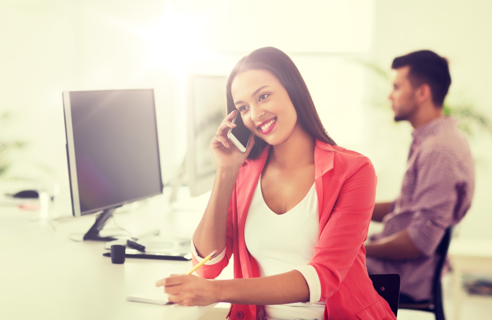 business, startup, communication and people concept - happy african american businesswoman or creative worker calling on smartphone at office. businesswoman calling on smartphone at office