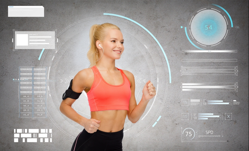 sport, exercise, technology, internet and healthcare - smiling sporty woman running and listening to music from smartphone in armband over gray concrete background. sporty woman running with smartphone and earphones