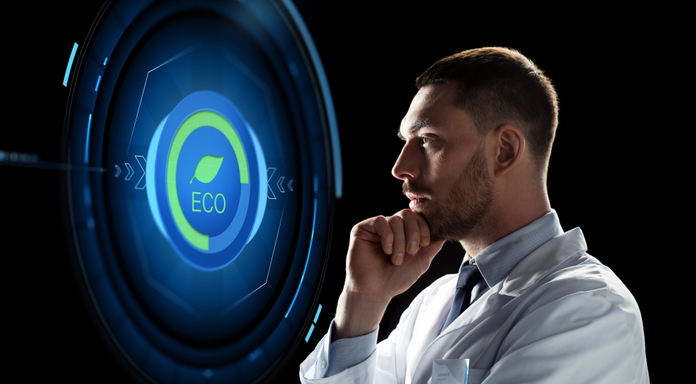 ecology, science and people concept - male doctor or scientist in white coat looking at virtual projection with eco icon over black background. scientist looking at virtual projection
