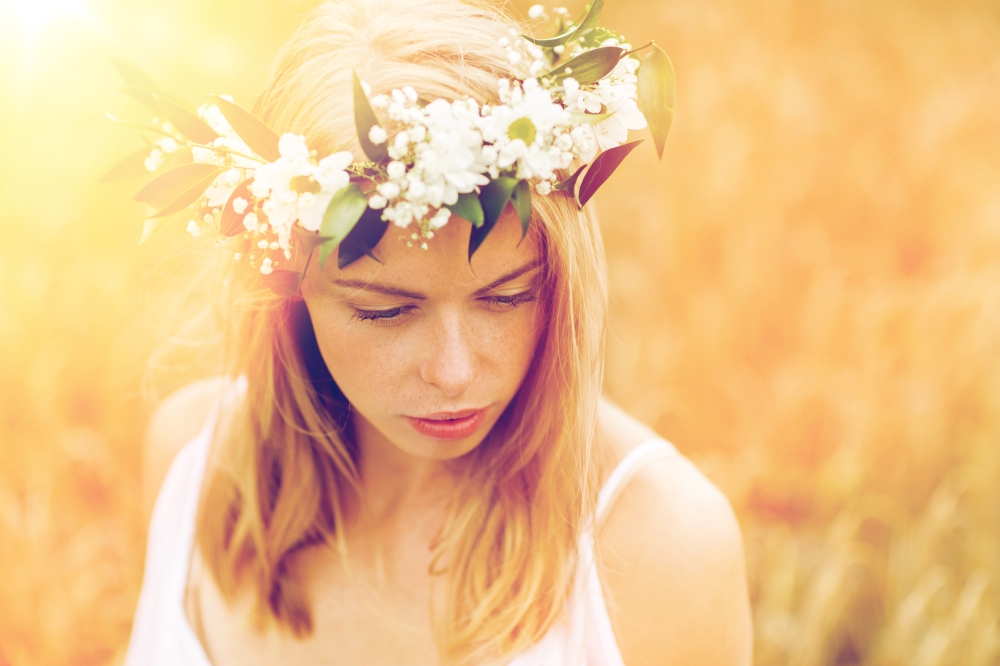 nature, summer holidays, vacation and people concept - face of happy woman in wreath of flowers. happy woman in wreath of flowers. happy woman in wreath of flowers