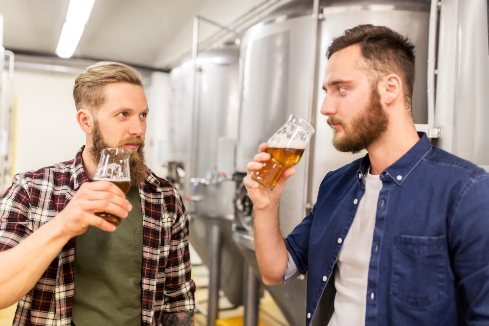 alcohol production, manufacture, business and people concept - men drinking and testing craft beer at brewery. men drinking and testing craft beer at brewery. men drinking and testing craft beer at brewery
