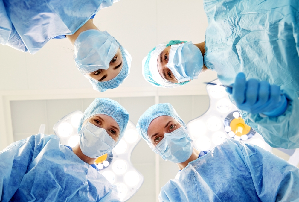 surgery, medicine and people concept - group of surgeons in operating room at hospital looking into camera. group of surgeons in operating room at hospital. group of surgeons in operating room at hospital