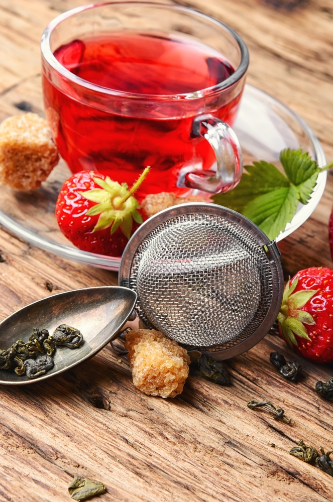 Summer strawberry tea. Summer fruit tea with strawberries in the rustic style