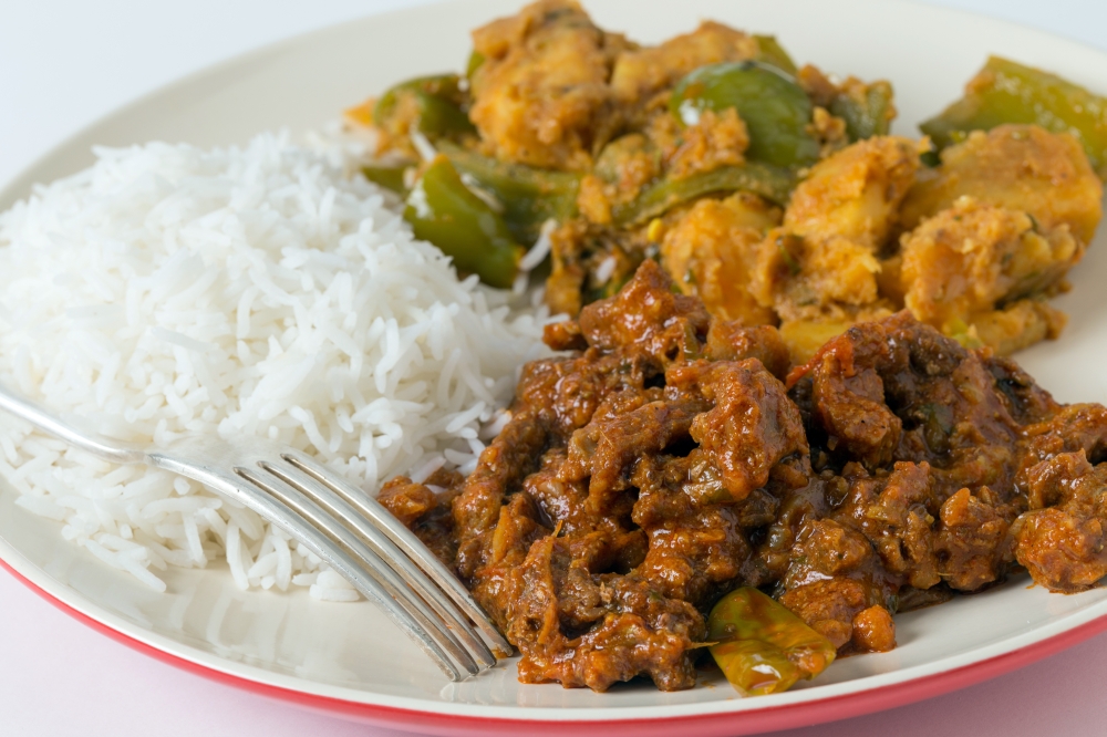 Indian roast beef curry with aloo capsicum, potato and bell pepper curry, and white rice.