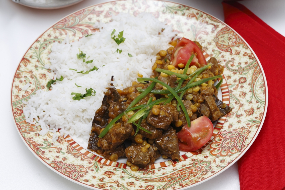 Lahore (Pakistan) style lamb and Chana dhal (split pea) curry, garnished with sliced chillies and chopped tomato, and served with white rice.