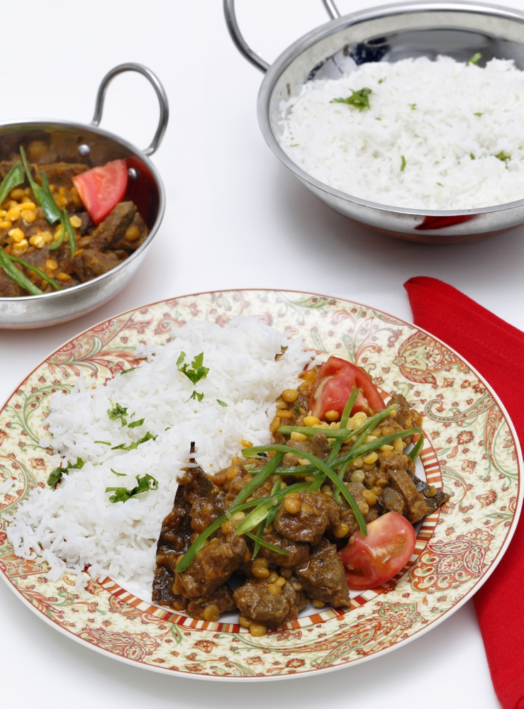 Lahore (Pakistan) style lamb and Chana dhal (split pea) curry, garnished with sliced chillies and chopped tomato, and served with white rice.