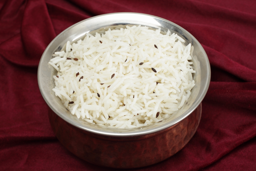 Jeera rice - long-grain basmati rice flavoured with fried cumin seeds - in a beaten copper and steel serving bowl