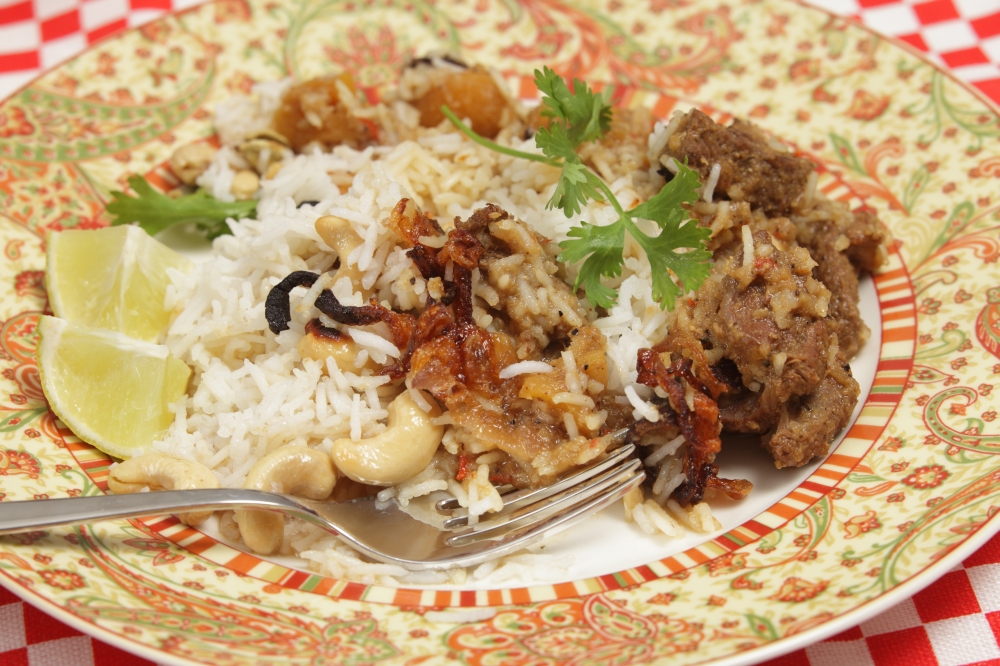 Adinner plate of home-made biryani-type fragrant lamb curry, cooked with dried apricots and yoghurt and garnished with toasted cashews, fried onions and coriander, served with cardamom-flavoured basmati rice.