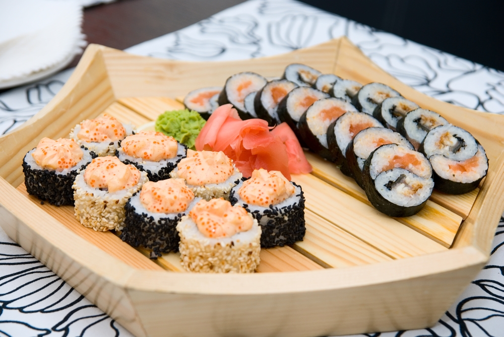 At restaurant: Set of sushi on wood plate.