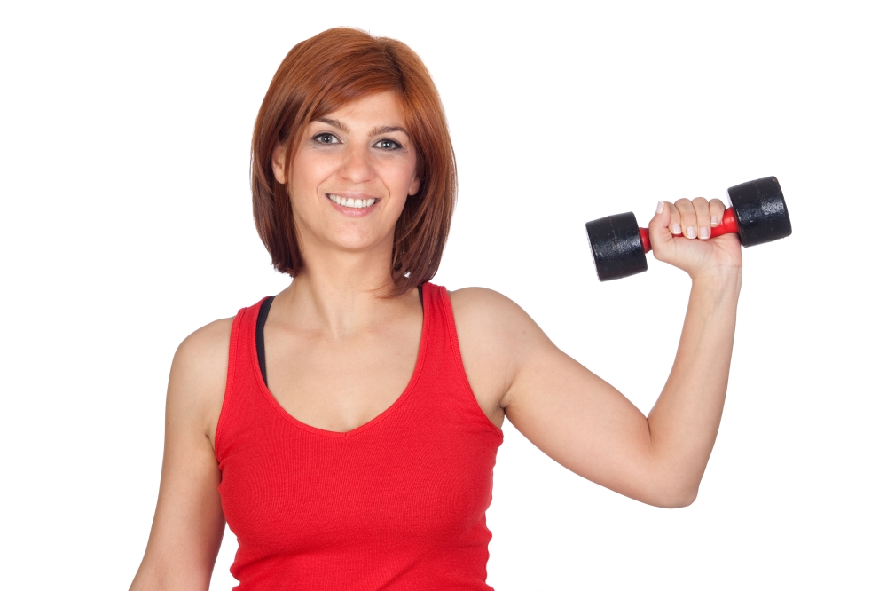 Beautiful redhead girl lifting weights isolated on a over white background