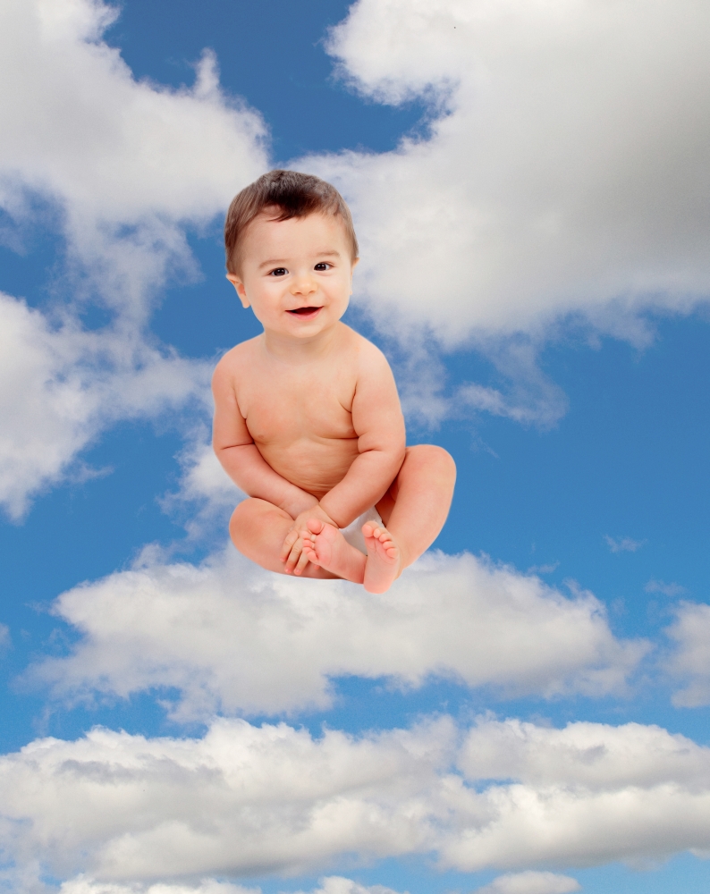 Funny baby in diaper sitting on a cloud on the sky