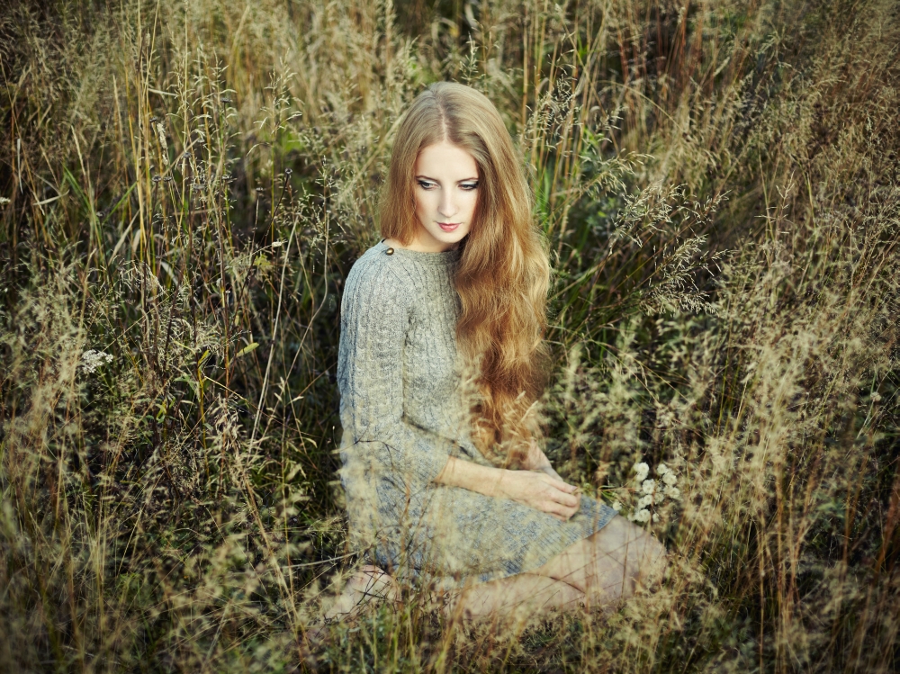 Portrait of beautiful woman on autumn field. Fashion photo