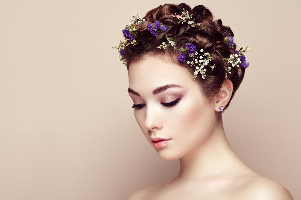 Face of beautiful woman decorated with flowers. Perfect makeup. Beauty fashion. Eyelashes. Cosmetic Eyeshadow