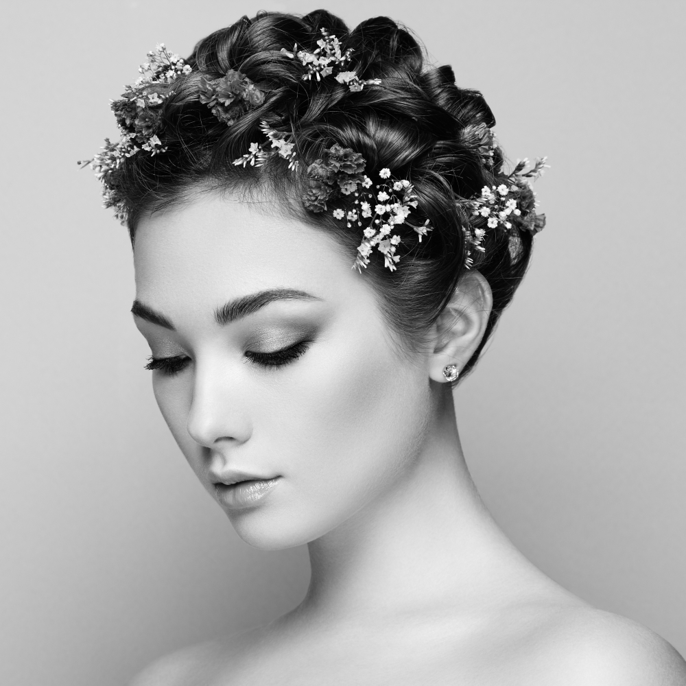 Face of beautiful woman decorated with flowers. Perfect makeup. Beauty fashion. Eyelashes. Cosmetic Eyeshadow. Black and White