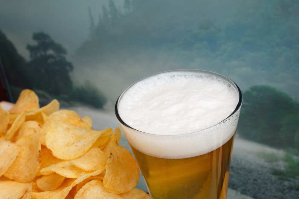 glass of beer and potato chips in a landscape